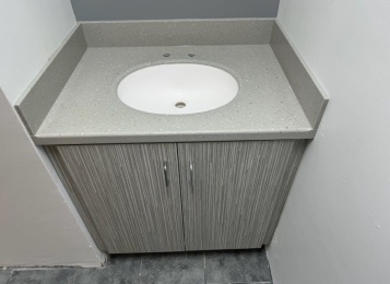 Custom made laminate cabinetry for a doctor's lounge with custom-made Corian tops and Corion full height backsplash. 
