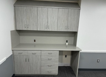 Custom made laminate cabinetry for a doctor's lounge with custom-made Corian tops and Corion full height backsplash. 
